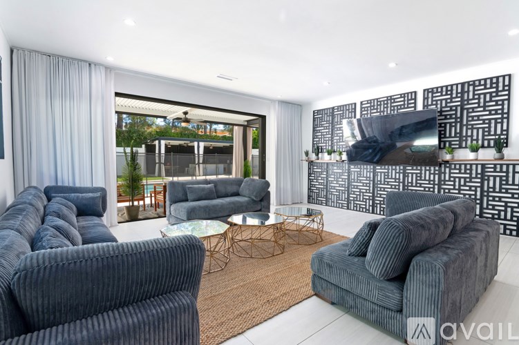 A living room with grey couches and a glass table.