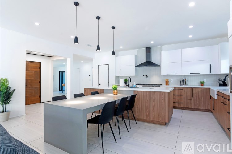 A modern kitchen with a dining table and chairs.