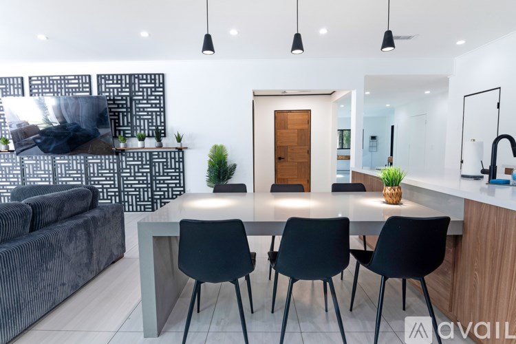A modern kitchen with a dining table and chairs.