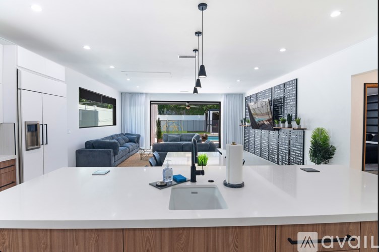 A modern kitchen with a large island and a view of the backyard.