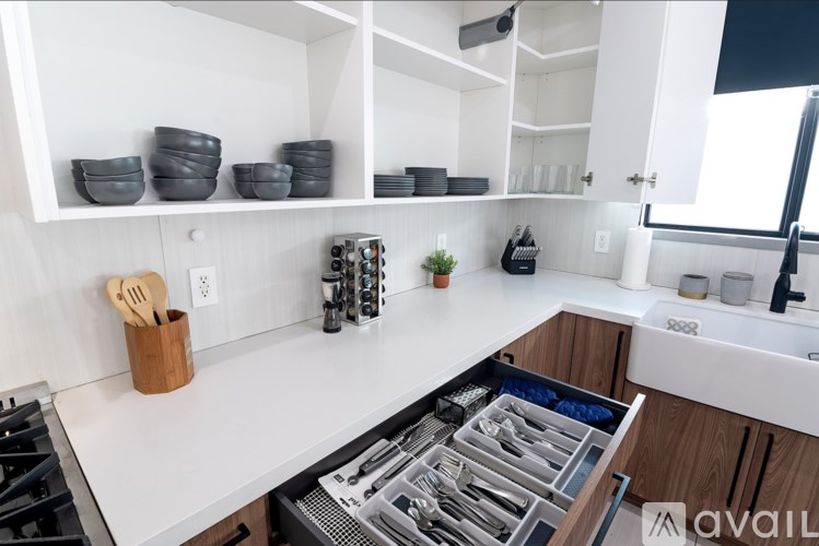 A kitchen with white countertops and wooden cabinets.