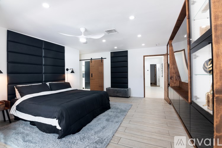 A bedroom with a large bed and a wooden floor.