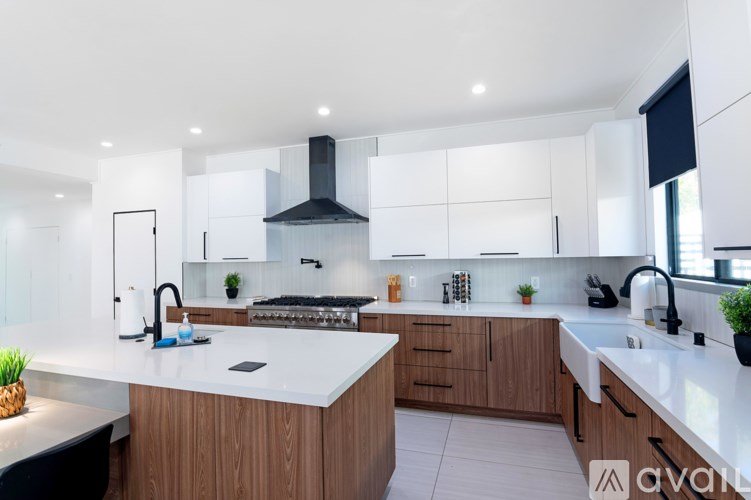 A modern kitchen with a large island and wooden cabinets.