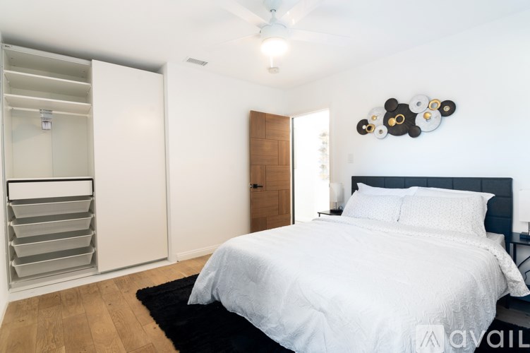 A bedroom with a large bed and a ceiling fan.