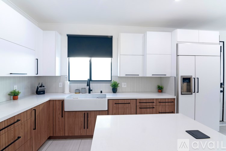 A kitchen with white cabinets and a white counter top.