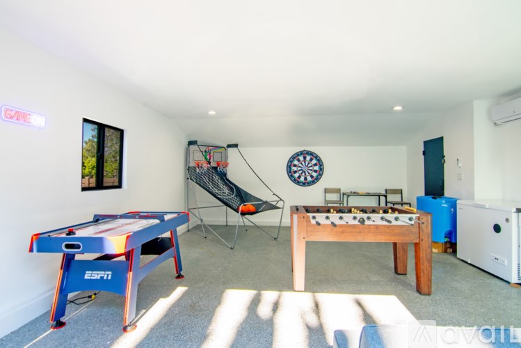 A room with a foosball table, air hockey table, and a slide.