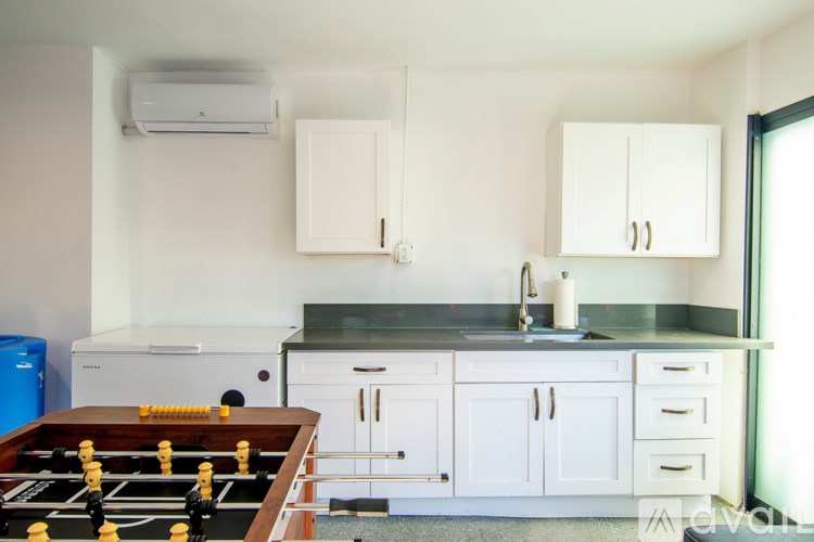 A foosball table is in the middle of a kitchen.