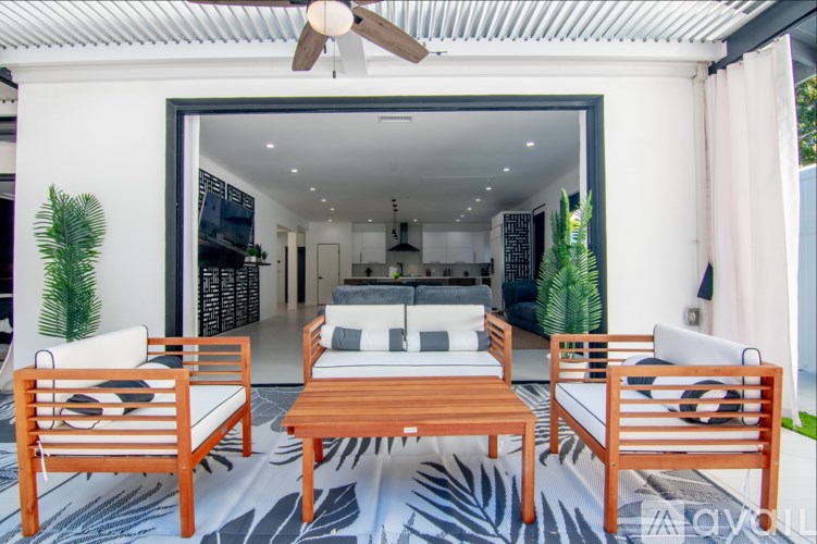 A white house with a patio furniture set.