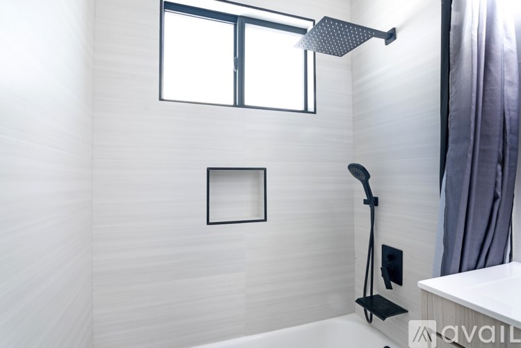 A bathroom with a white tub and a window.
