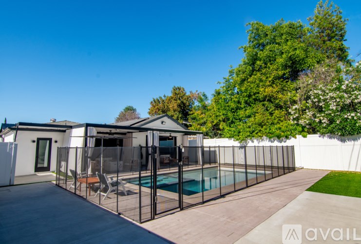 A house with a pool surrounded by a fence.
