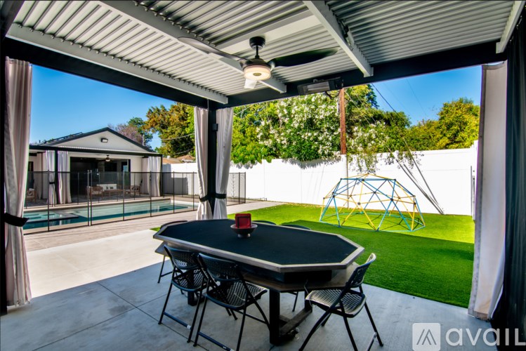 A patio with a table and chairs and a ceiling fan.