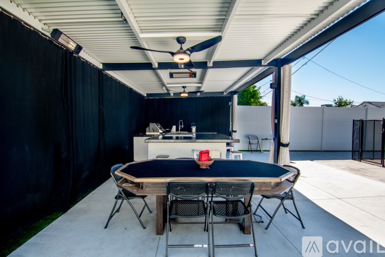 A patio with a table and chairs under a roof.
