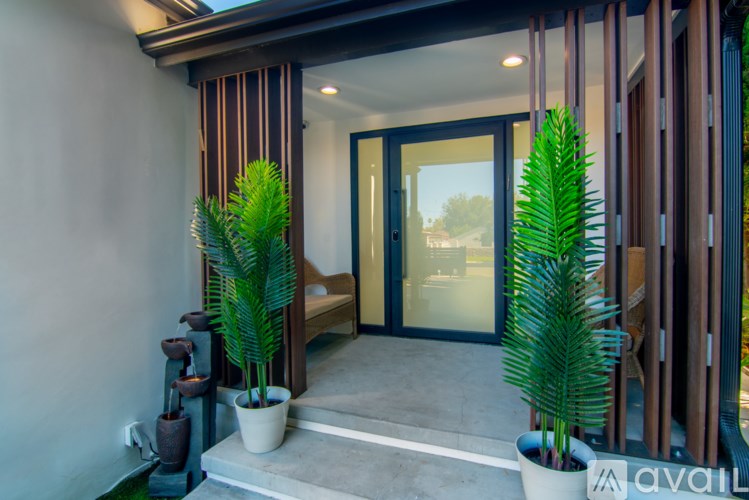 A modern house entrance with a glass door and a bench.
