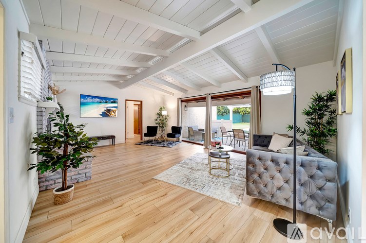 A living room with a grey sofa and a wooden floor.