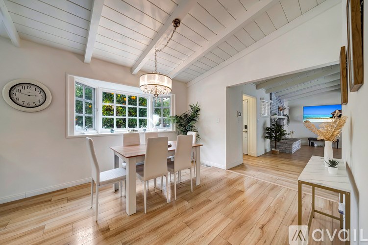 A dining room with a wooden table and chairs.