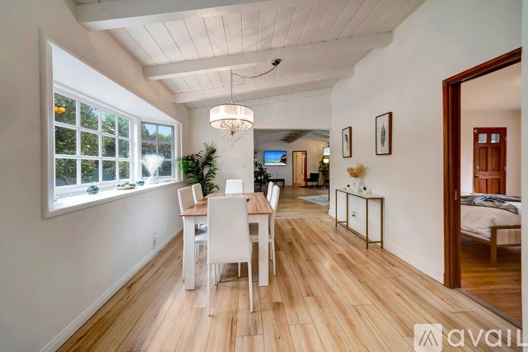 A room with a dining table and chairs is available for rent.