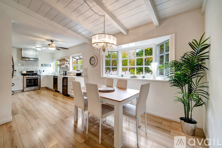 A kitchen with a dining table and chairs.