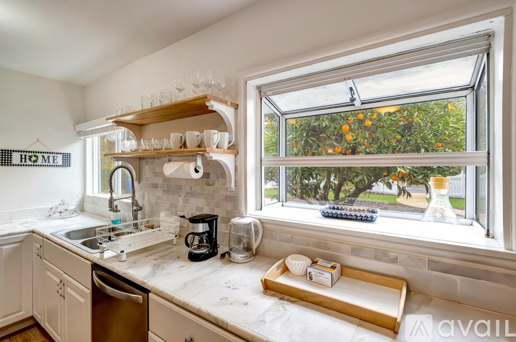 A kitchen with a window overlooking a garden.
