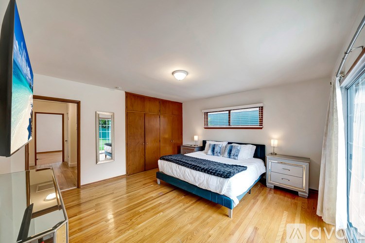 A bedroom with a bed, nightstand, and chair.