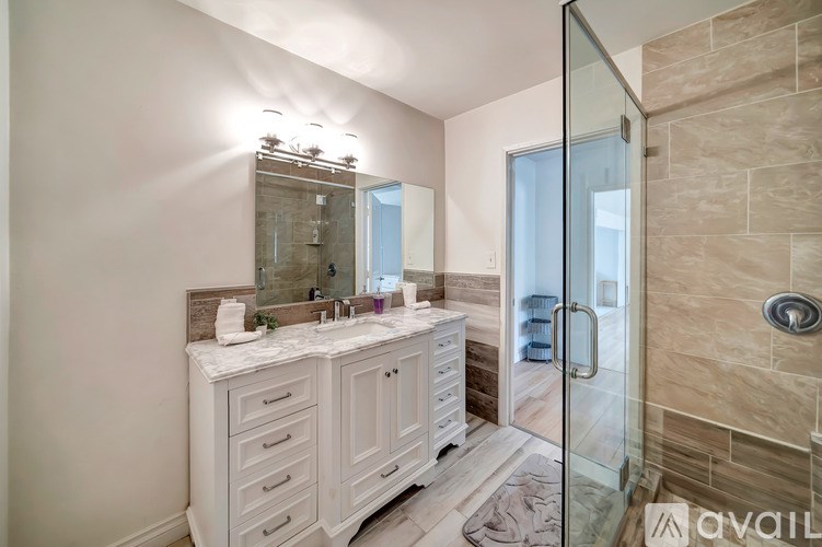 A bathroom with a marble countertop and a walk-in shower.
