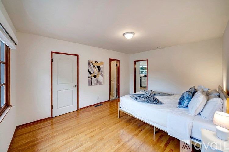 A bedroom with a bed, a couch, and a window.