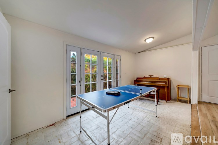 A room with a ping pong table and a piano.