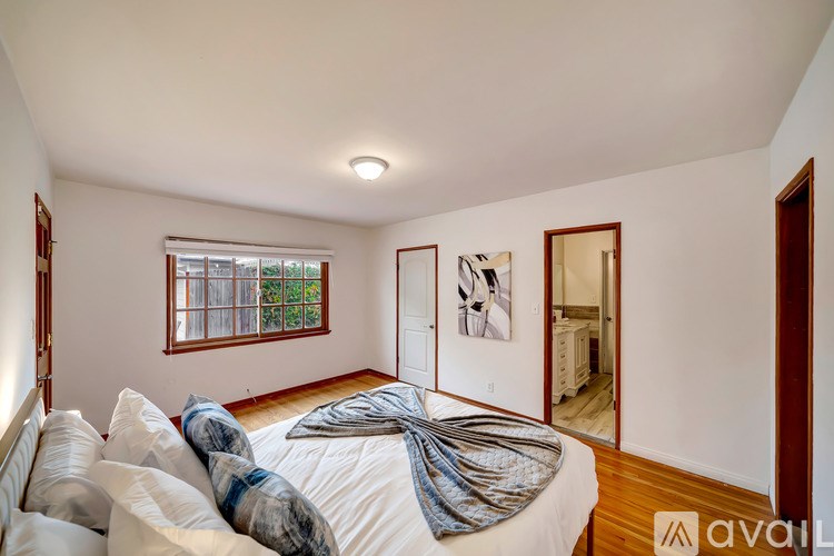 A bedroom with a bed and a window.