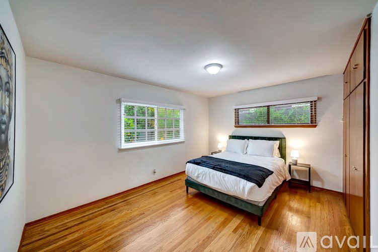 A bedroom with a bed, nightstand, and window.