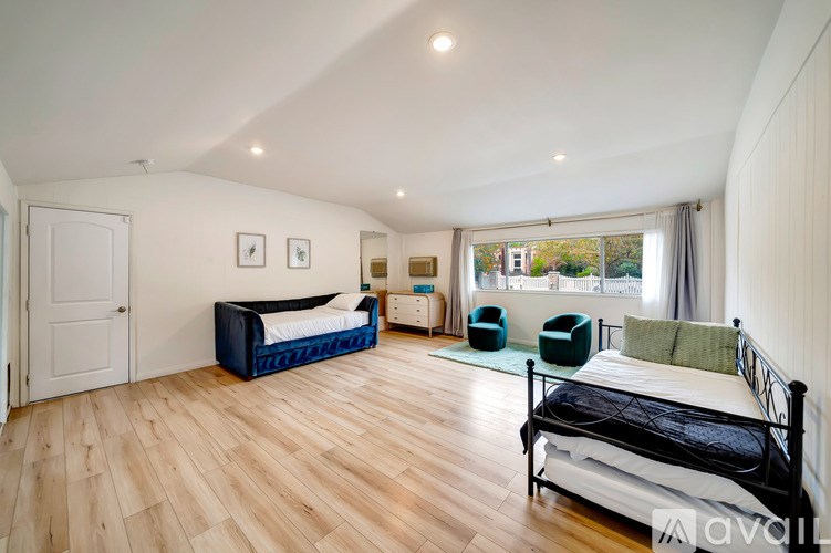 A bedroom with a bed, a couch, and a chair.