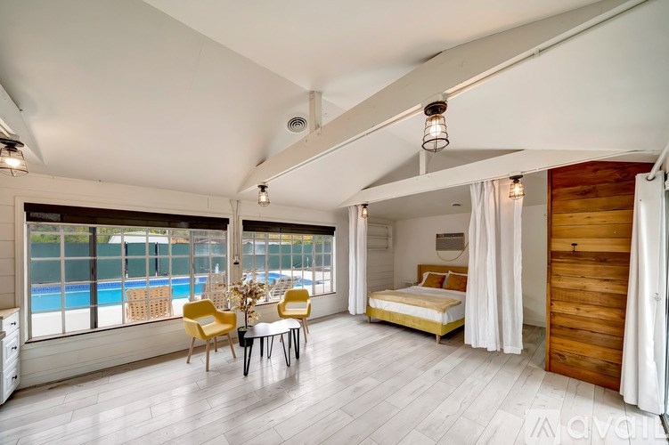 A large, bright room with a pool outside the window.