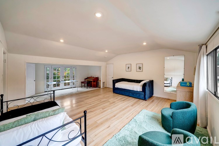 A bedroom with a bed, a chair, and a couch.