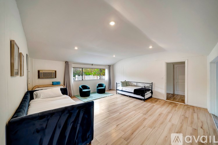 A bedroom with a large bed and a balcony with a view of the city.