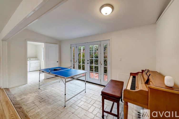 A room with a table, a piano, and a pool table.