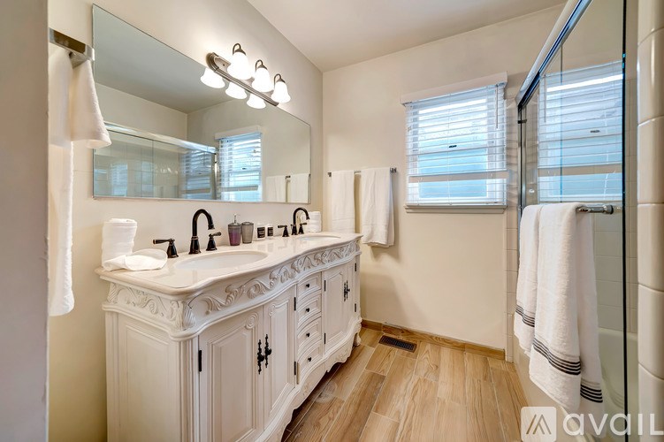 A bathroom with a white vanity and a mirror above it.
