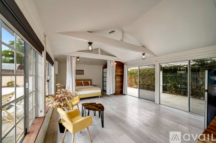 A bedroom with a bed, a chair, and a table is shown.