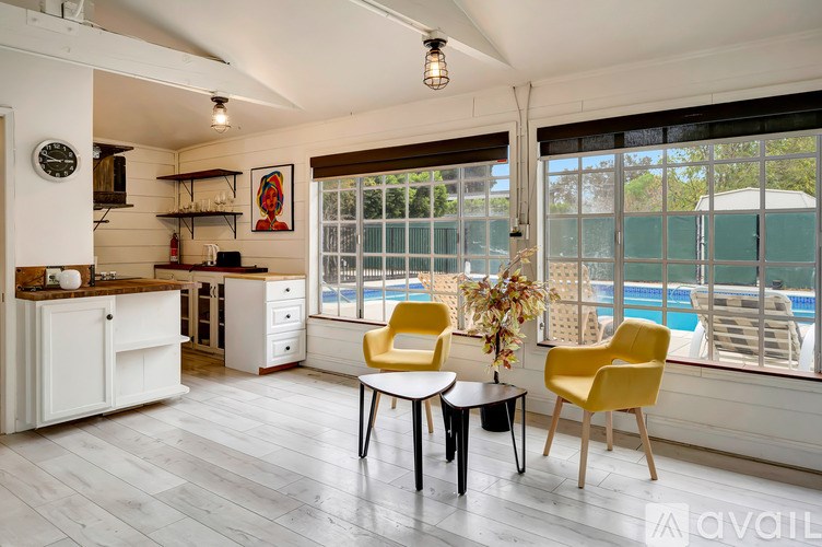 A kitchen with a table and chairs by a window.