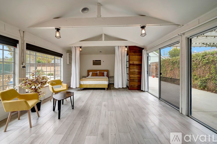 A living room with a yellow chair and a white sofa.