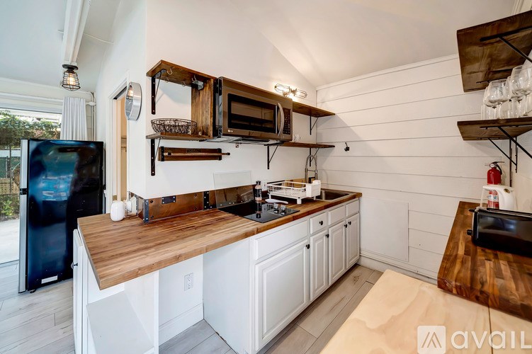 A kitchen with white cabinets and a wooden countertop.