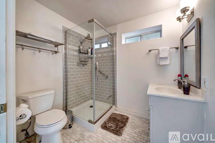 A bathroom with a toilet, sink, and shower.