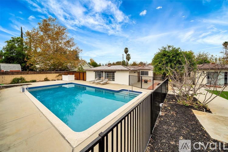 A swimming pool in a backyard with a house in the background.