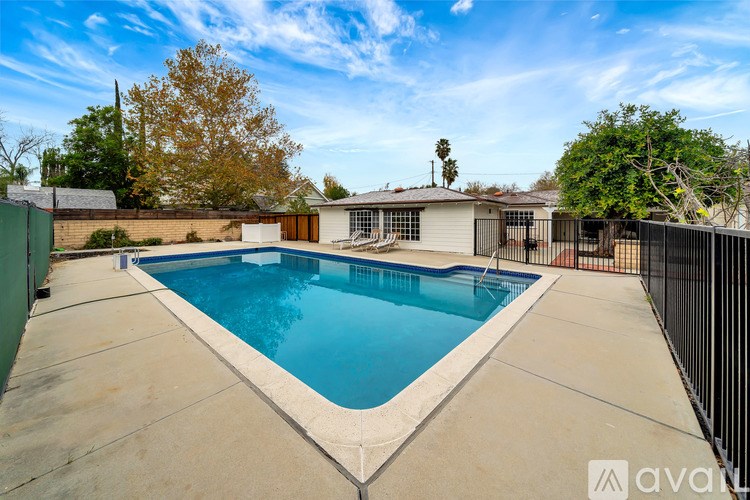 A swimming pool in a backyard surrounded by a fence.