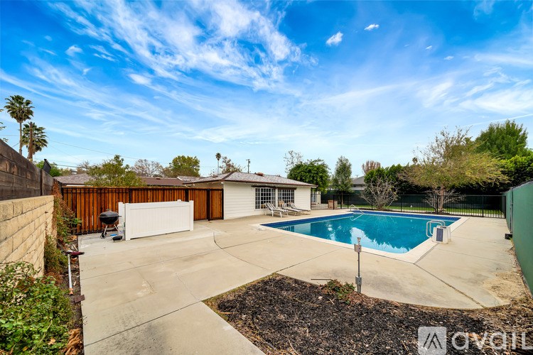 A backyard with a pool and a fence.