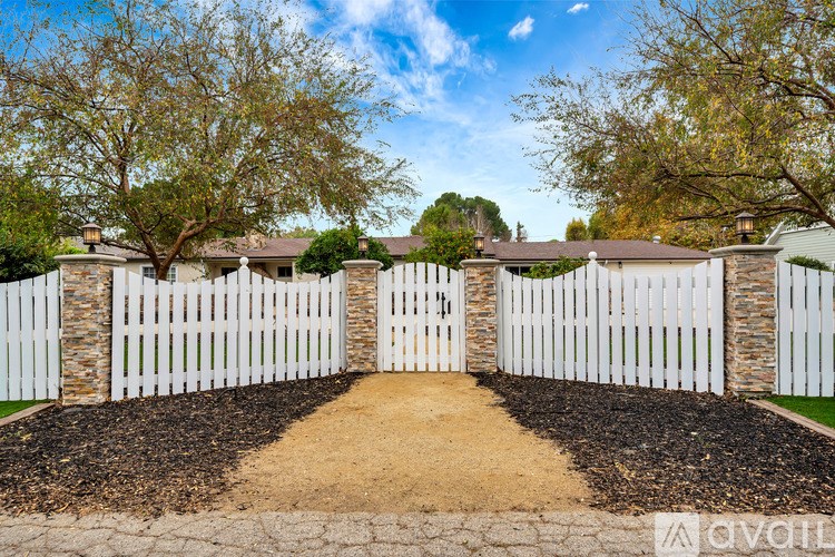 A white picket fence encloses a residential area.