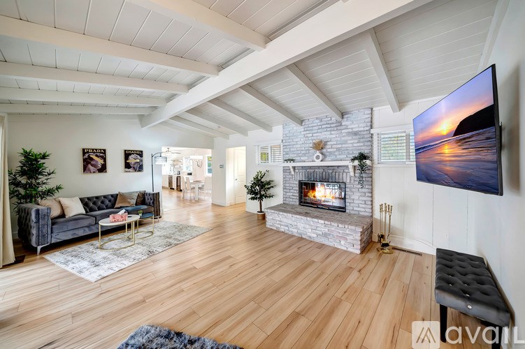 A modern living room with a fireplace and a flat screen TV mounted on the wall.