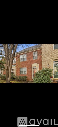 A brick house with a tree in front.