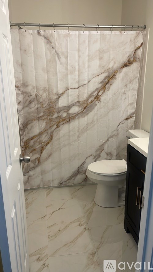 A bathroom with a marble shower and toilet.