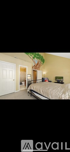 A bedroom with a bed, nightstand, and a painting on the wall.