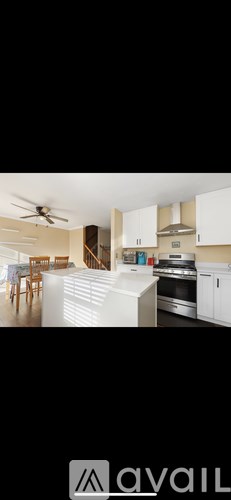 A modern kitchen with white cabinets and appliances.