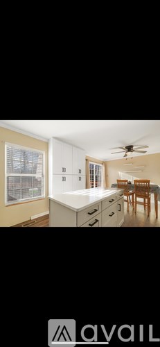 A kitchen with a dining table and chairs.
