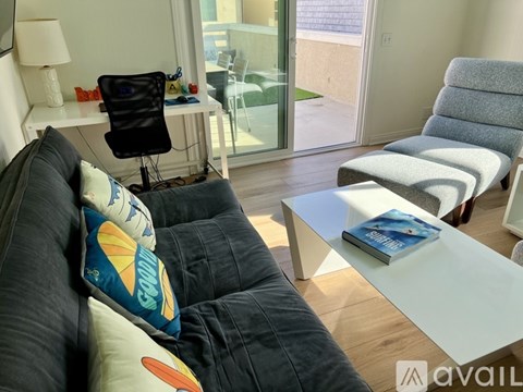 A living room with a black chair and a white couch.